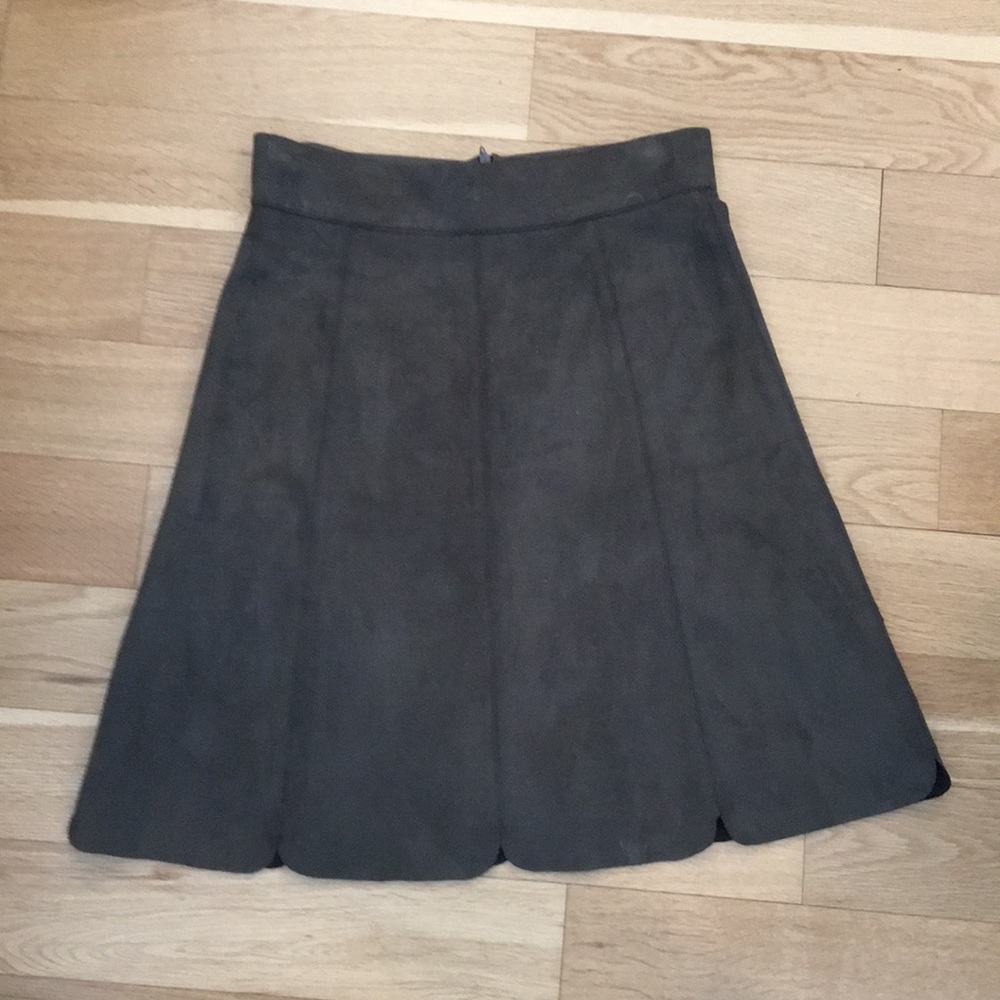 Green suede scalloped, knee-length skirt.